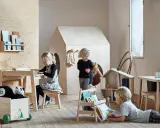 Dzieci bawią się i uczą przy stoliku sensorycznym IKEA FLISAT w pokoju zabaw.