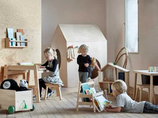 Dzieci bawią się i uczą przy stoliku sensorycznym IKEA FLISAT w pokoju zabaw.