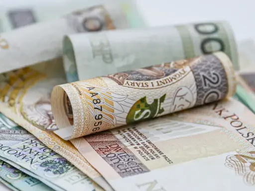 Zrolowane polskie banknoty o nominałach 20, 100 i 200 złotych.